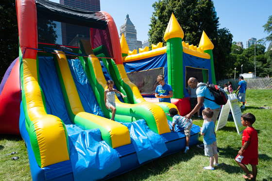 Kids playing on an inflatable slide in a park